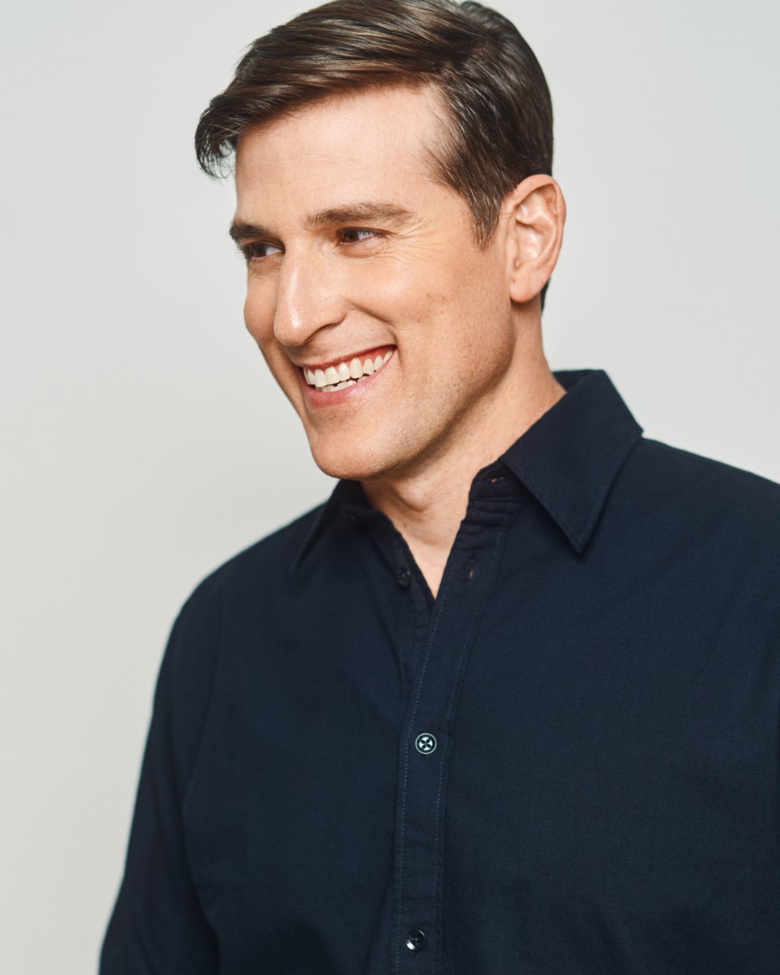 Jonathan Chase Greenfield smiling, in a dark button-down shirt