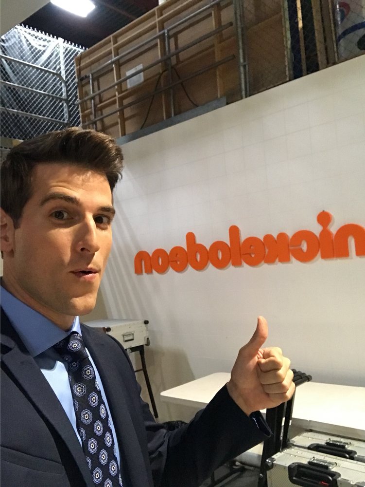 Jonathan giving a thumbs-up in front of a Nickelodeon sign